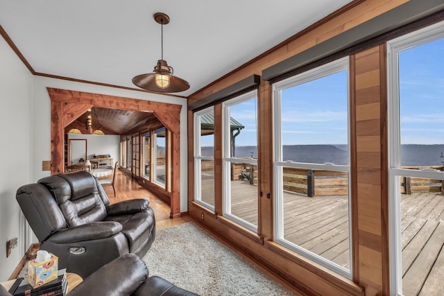 sunroom with lofted ceiling and a water view