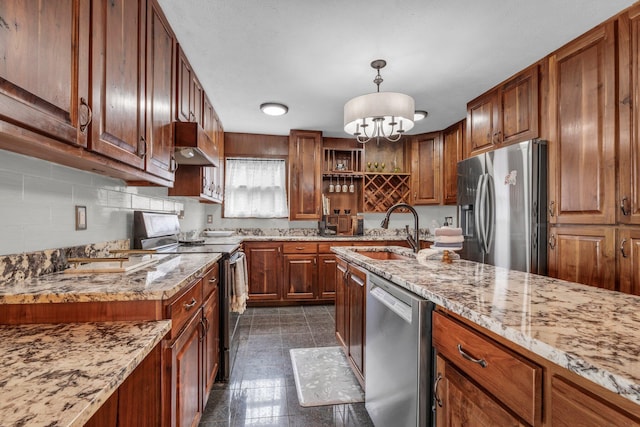 kitchen with sink, decorative light fixtures, backsplash, stainless steel appliances, and light stone countertops