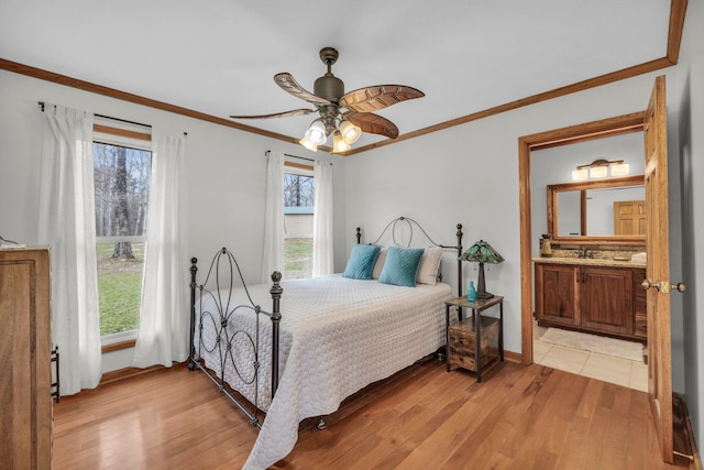 bedroom with light hardwood / wood-style floors, sink, multiple windows, and ceiling fan