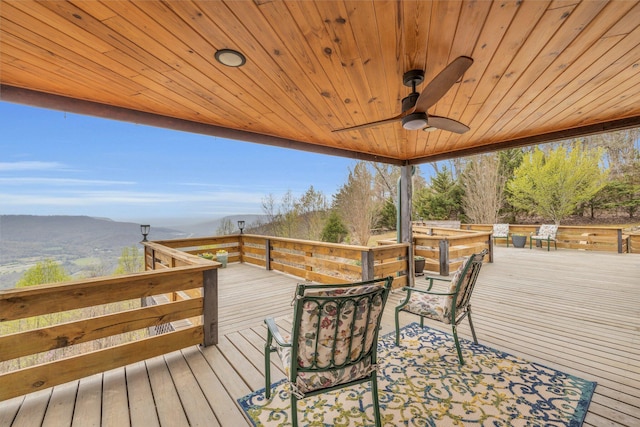 wooden deck with ceiling fan and a mountain view