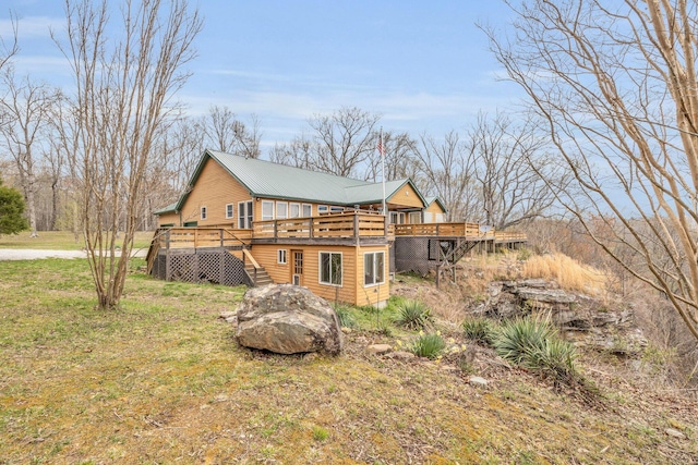 back of house with a wooden deck and a lawn