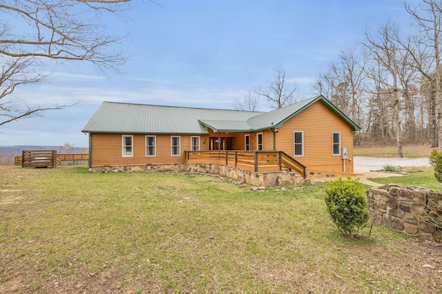 back of house featuring a wooden deck and a lawn