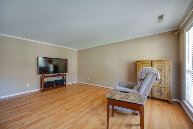 sitting room featuring crown molding, light wood-style flooring, baseboards, and visible vents