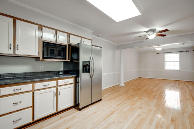 kitchen featuring stainless steel refrigerator with ice dispenser, dark countertops, black microwave, crown molding, and ornate columns