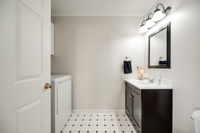 half bathroom featuring washer / clothes dryer, toilet, ornamental molding, and vanity