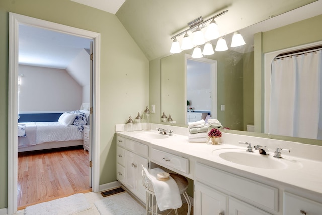 bathroom with vanity, lofted ceiling, toilet, and wood-type flooring