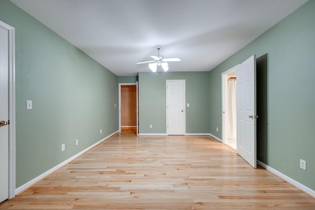 unfurnished bedroom featuring ceiling fan, light wood-type flooring, and baseboards