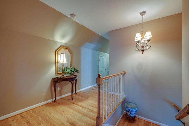 stairs featuring a chandelier and hardwood / wood-style floors