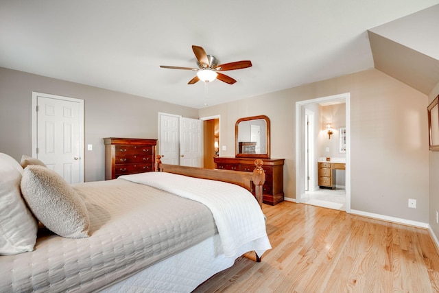 bedroom with ceiling fan, vaulted ceiling, light hardwood / wood-style floors, and ensuite bath