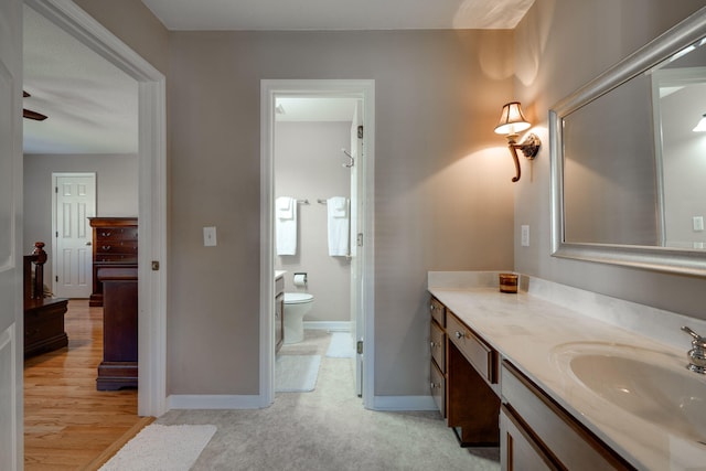 bathroom featuring toilet, hardwood / wood-style floors, and vanity