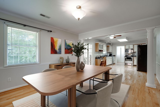 dining room with visible vents, crown molding, and light wood finished floors