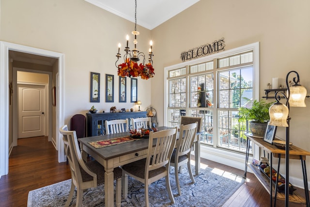 dining room with crown molding, a chandelier, and dark hardwood / wood-style floors