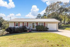 ranch-style home with an attached garage, concrete driveway, and a front yard