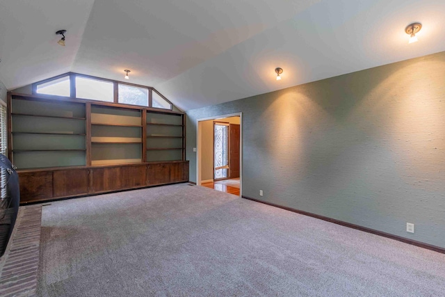 bonus room with lofted ceiling, built in shelves, and carpet flooring