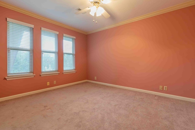 carpeted empty room featuring crown molding, baseboards, and a ceiling fan