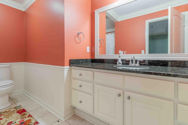 bathroom featuring crown molding, tile patterned flooring, wainscoting, and toilet