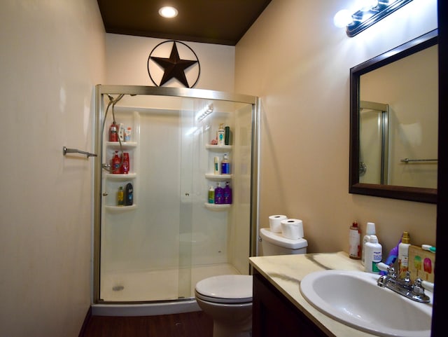 bathroom featuring wood-type flooring, vanity, toilet, and an enclosed shower