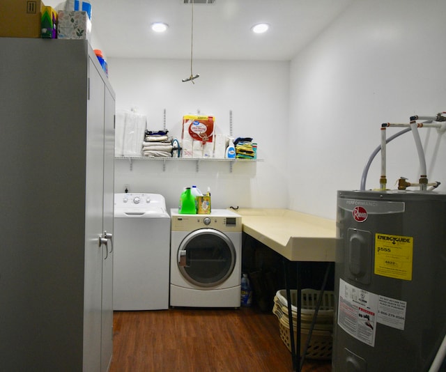 laundry area with washing machine and dryer, dark hardwood / wood-style floors, and electric water heater