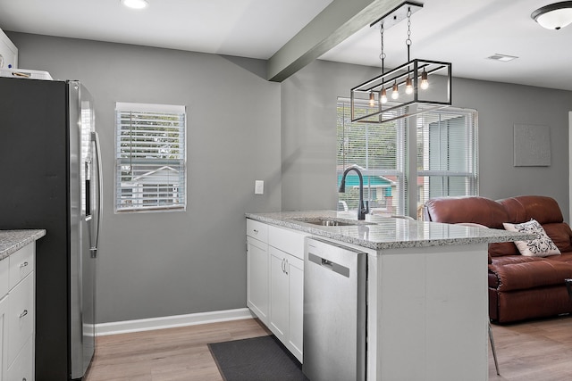 kitchen with appliances with stainless steel finishes, sink, kitchen peninsula, light hardwood / wood-style floors, and white cabinets