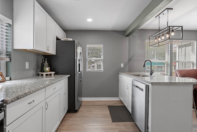 kitchen featuring sink, light wood-type flooring, white cabinetry, stainless steel appliances, and light stone counters