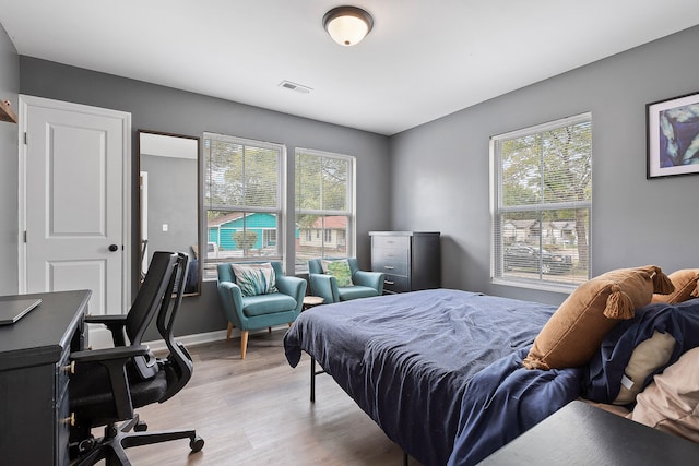 bedroom with light hardwood / wood-style flooring and multiple windows