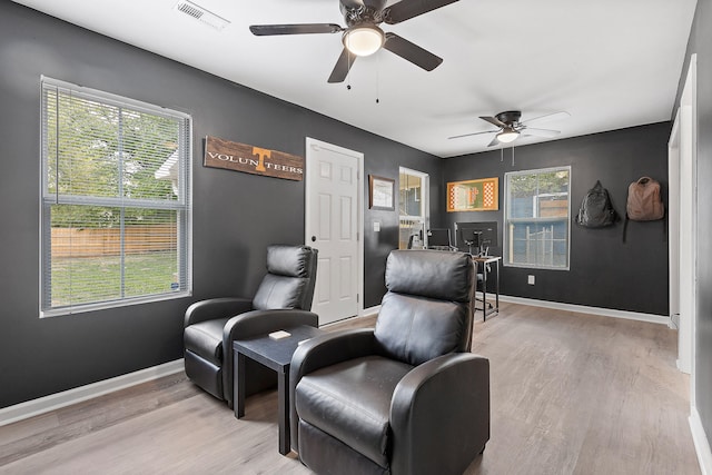 sitting room featuring ceiling fan, a healthy amount of sunlight, and light wood-type flooring