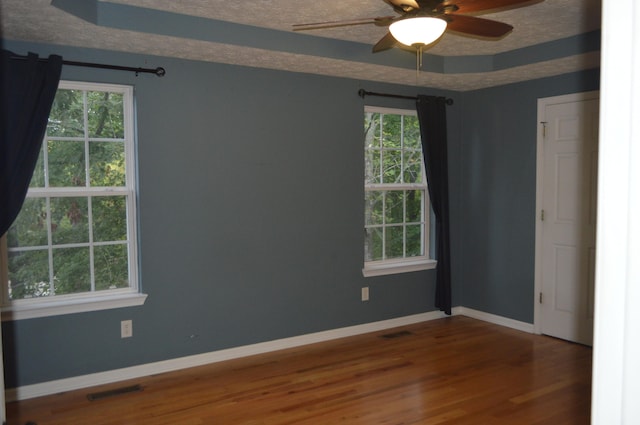 empty room featuring ceiling fan, a textured ceiling, and hardwood / wood-style floors