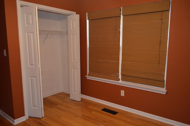 unfurnished bedroom with hardwood / wood-style flooring and a closet