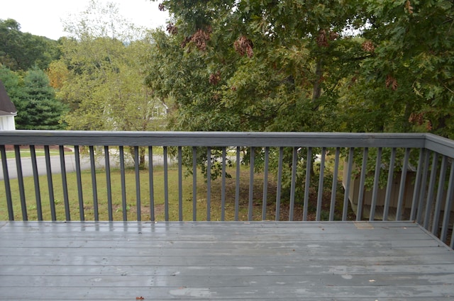 wooden deck featuring a lawn