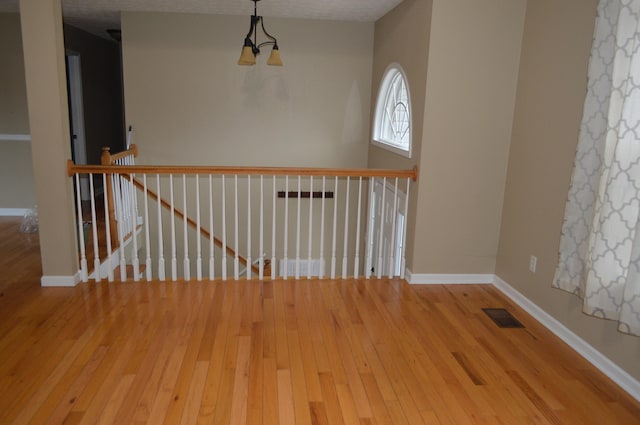 unfurnished room featuring a textured ceiling and hardwood / wood-style flooring