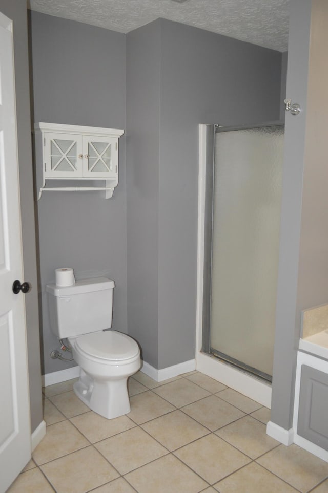 bathroom with toilet, tile patterned flooring, vanity, a textured ceiling, and walk in shower