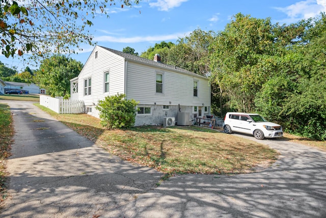 view of front of house featuring a front yard, central AC, and ac unit