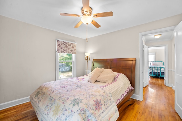 bedroom featuring ceiling fan, hardwood / wood-style flooring, and crown molding