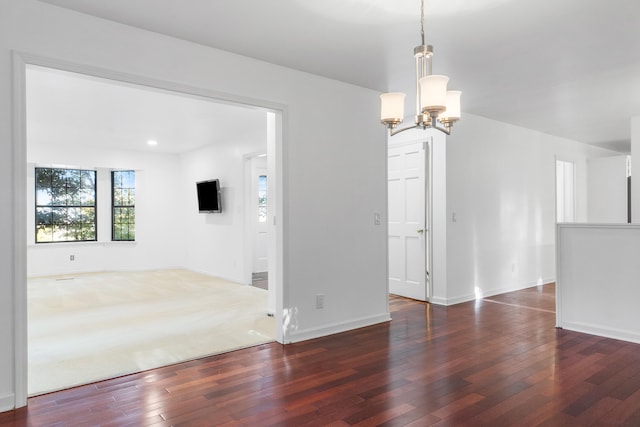 empty room featuring dark hardwood / wood-style flooring and an inviting chandelier