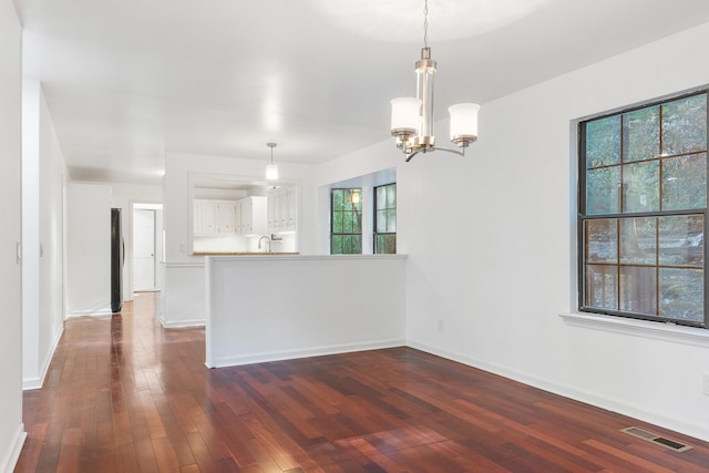 interior space with a wealth of natural light, sink, dark wood-type flooring, and a chandelier