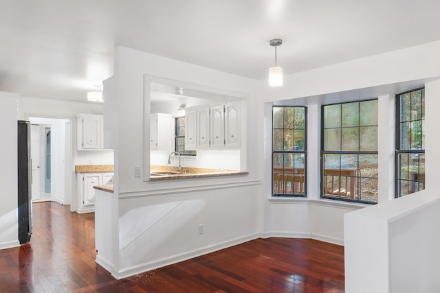 kitchen featuring white cabinets, decorative light fixtures, sink, and dark hardwood / wood-style floors