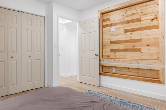 unfurnished bedroom with a closet and light wood-type flooring