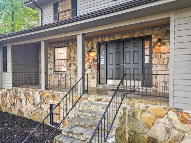 view of exterior entry featuring covered porch