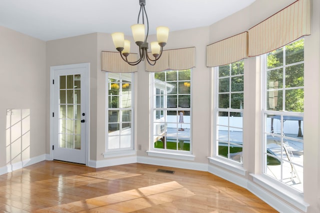 doorway featuring light hardwood / wood-style flooring and a notable chandelier