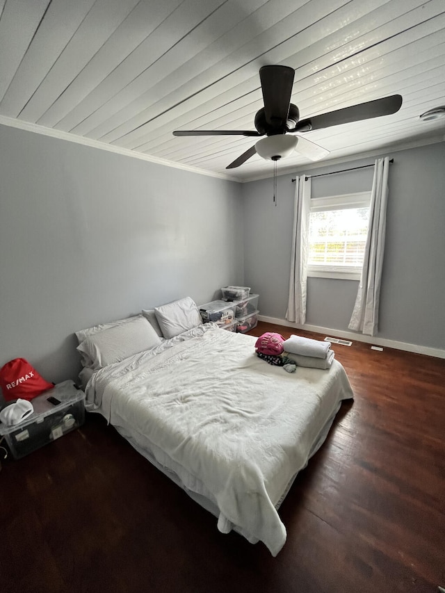 bedroom featuring dark hardwood / wood-style floors, ceiling fan, and ornamental molding