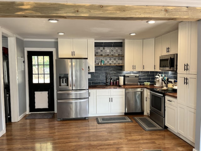 kitchen featuring sink, ornamental molding, dark hardwood / wood-style flooring, white cabinetry, and stainless steel appliances