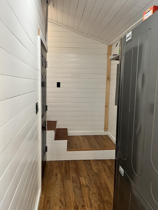 interior space with dark hardwood / wood-style flooring and wooden walls