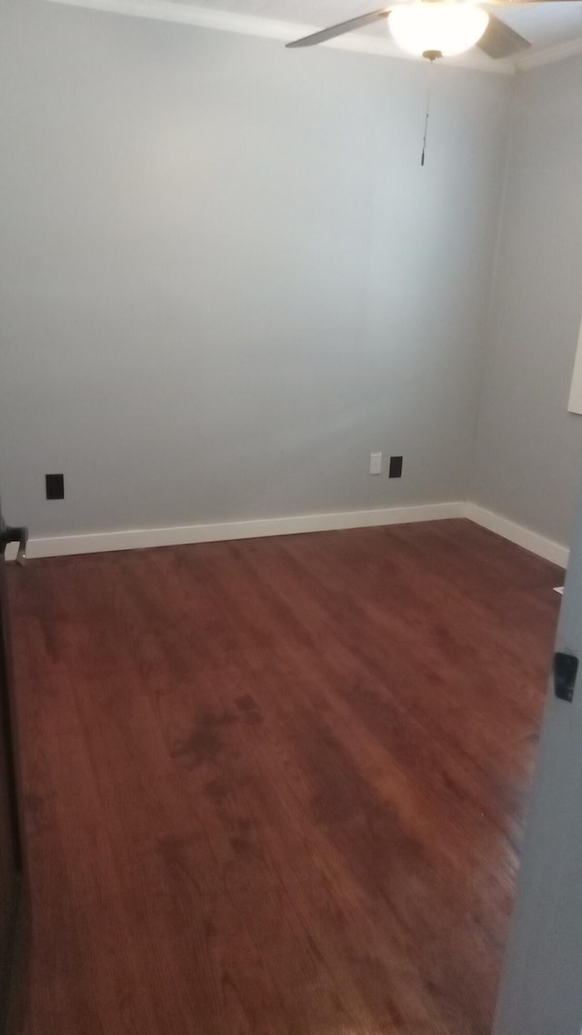 empty room with dark hardwood / wood-style flooring and ceiling fan