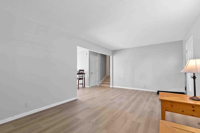 living room featuring light wood-type flooring and a textured ceiling