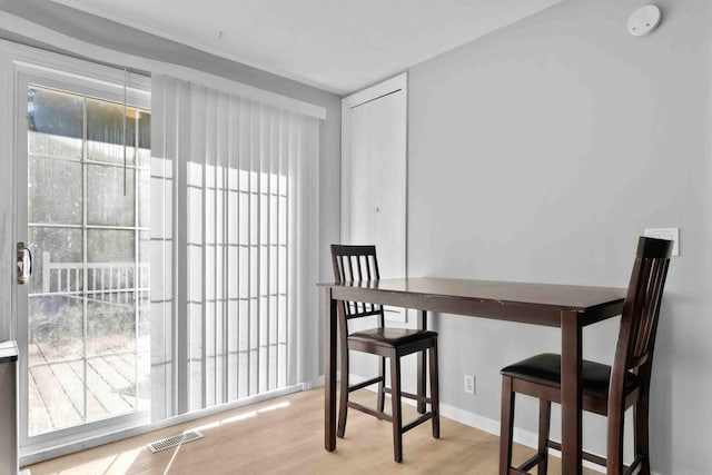 dining room with light hardwood / wood-style floors and a textured ceiling