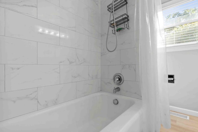 bathroom featuring shower / tub combo and hardwood / wood-style floors