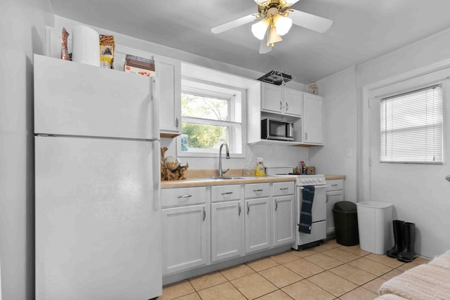 kitchen with light tile patterned flooring, ceiling fan, white appliances, sink, and white cabinetry