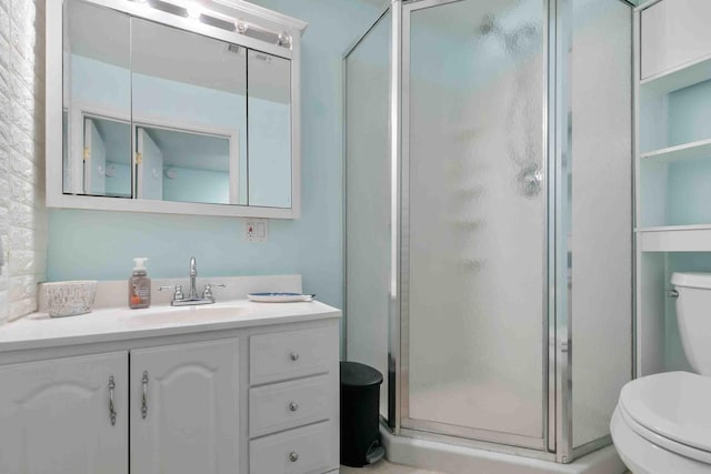 bathroom featuring an enclosed shower, vanity, and toilet