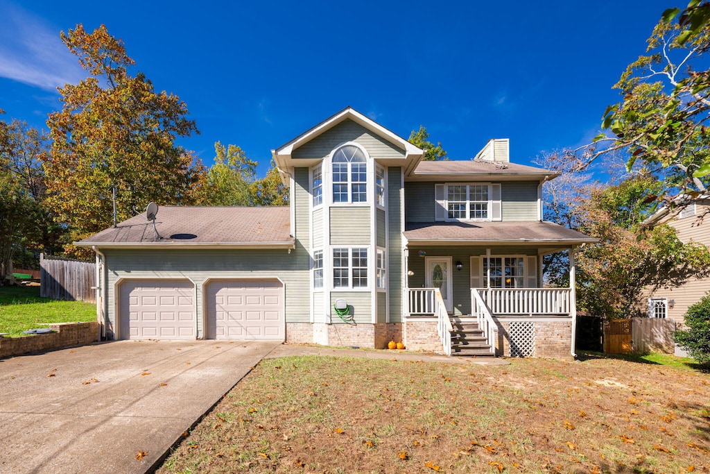 view of front property with a garage, a front yard, and covered porch