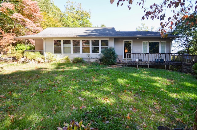 ranch-style home with a deck and a front lawn